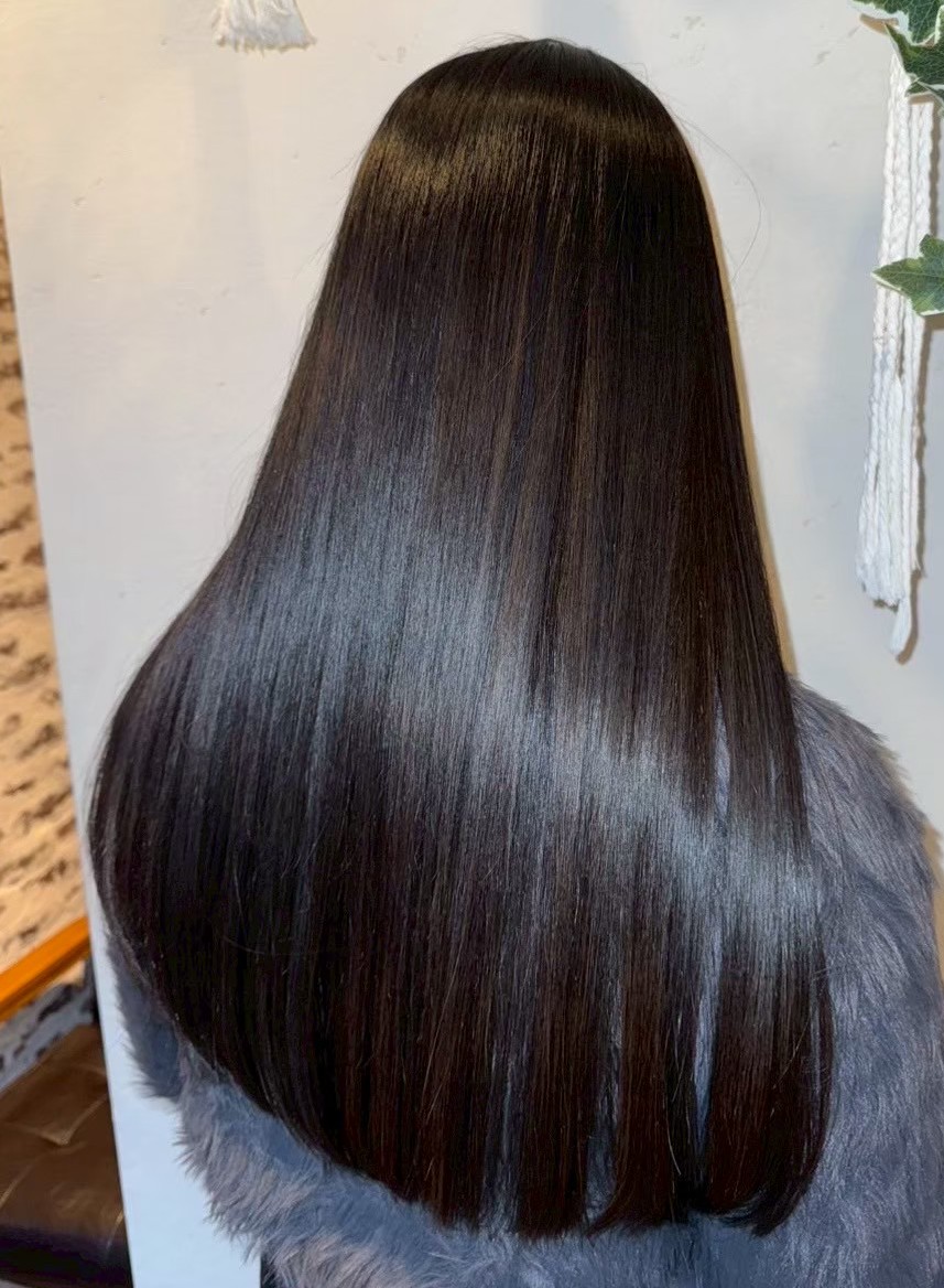 ツヤのあるダークブラウンのロングストレートヘアを後ろから撮影した写真